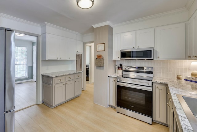 3866 Villa Ln, Martinez, GA 30907 - kitchen featuring stainless steel appliances, light wood-style flooring, decorative backsplash, light stone countertops, and ornamental molding