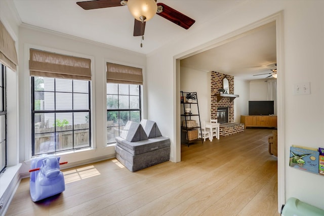 3866 Villa Ln, Martinez, GA 30907 - sitting room featuring a ceiling fan, light wood-type flooring, plenty of natural light, ornamental molding, and a fireplace