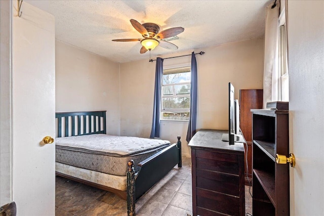 bedroom featuring ceiling fan and a textured ceiling