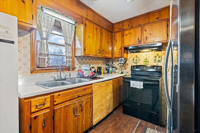 kitchen with stainless steel refrigerator, black electric range oven, sink, fridge, and dark wood-type flooring