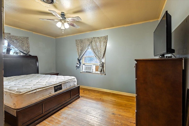 bedroom featuring multiple windows, crown molding, and light hardwood / wood-style floors