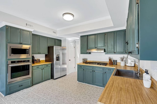 2928 Foxhall Cir, Augusta, GA 30907 - kitchen with appliances with stainless steel finishes, green cabinets, under cabinet range hood, a sink, and ornamental molding