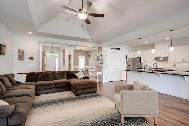 living room with recessed lighting, a ceiling fan, dark wood-type flooring, and vaulted ceiling