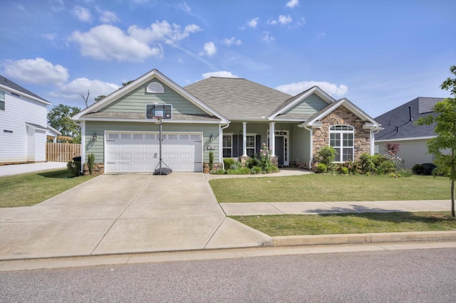 craftsman-style house featuring a front yard, a garage, driveway, stone siding, and fence