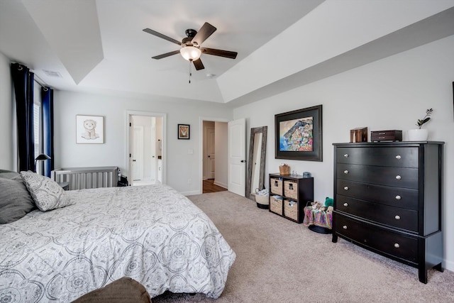carpeted bedroom with a ceiling fan, visible vents, and a raised ceiling
