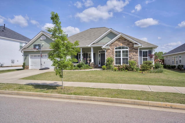 craftsman inspired home featuring concrete driveway, stone siding, covered porch, an attached garage, and a front lawn
