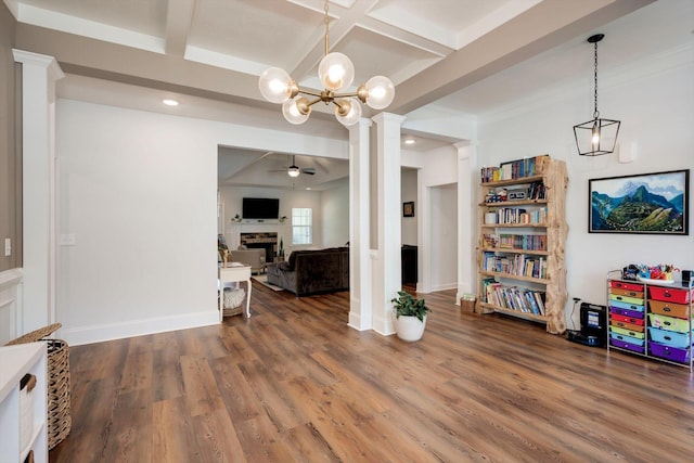 interior space with coffered ceiling, decorative columns, wood finished floors, and ceiling fan with notable chandelier