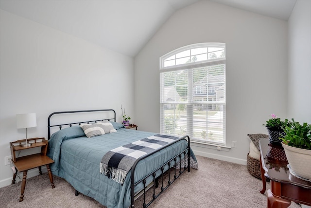 carpeted bedroom featuring lofted ceiling and baseboards