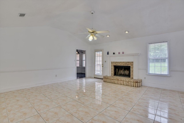 unfurnished living room with ceiling fan, lofted ceiling, and a brick fireplace