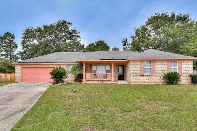 ranch-style home with covered porch, a garage, and a front yard