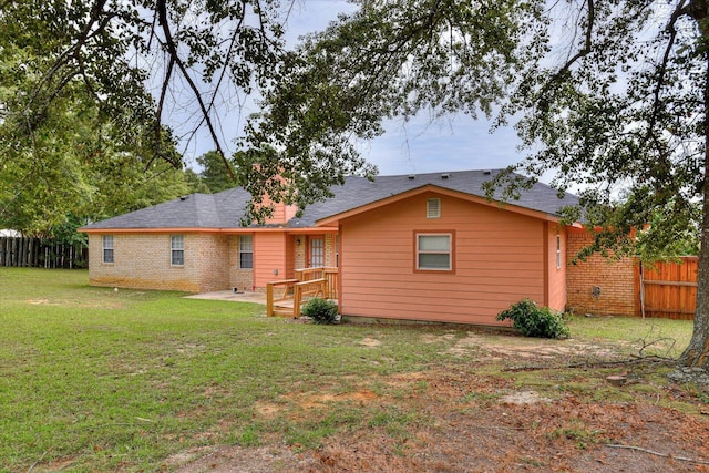 back of property with a patio area and a yard