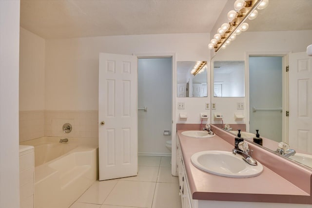 bathroom featuring a tub, tile patterned floors, a textured ceiling, toilet, and vanity