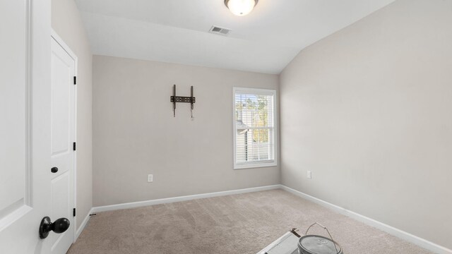 unfurnished room with visible vents, baseboards, carpet, and lofted ceiling