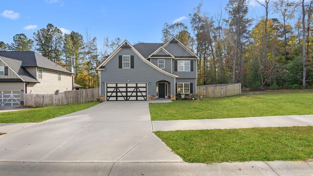 view of front of home featuring a front yard, an attached garage, driveway, and fence