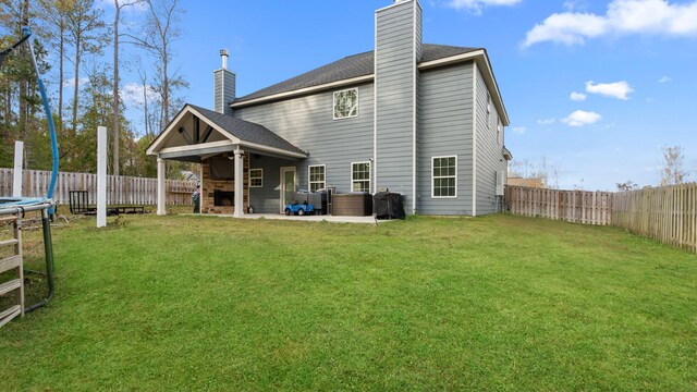 rear view of property with ceiling fan, a yard, a fenced backyard, and a chimney