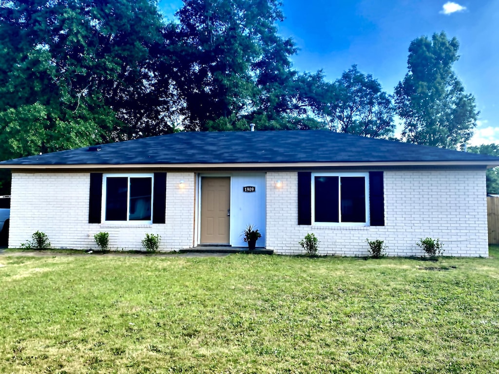 single story home with a front lawn