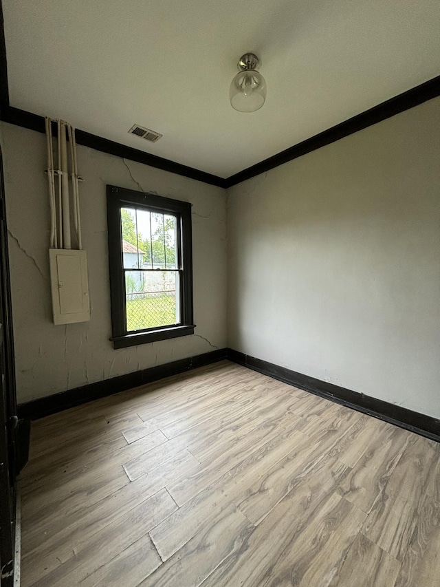 unfurnished room with light hardwood / wood-style flooring and ornamental molding