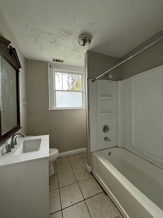 full bathroom with tile patterned floors, vanity,  shower combination, a textured ceiling, and toilet