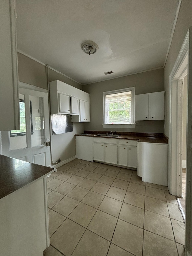 kitchen featuring light tile patterned flooring, white cabinetry, and sink