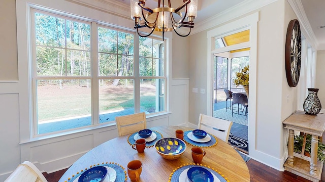 dining space featuring a notable chandelier, dark hardwood / wood-style flooring, and crown molding