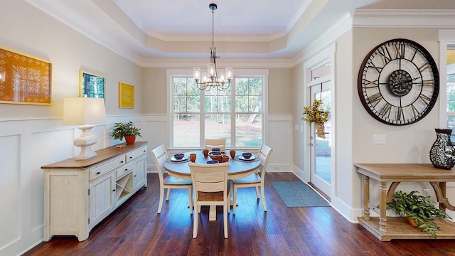 dining space with a tray ceiling, crown molding, a chandelier, and dark hardwood / wood-style floors