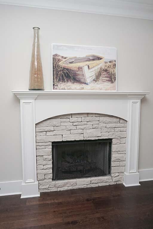 room details with a stone fireplace, wood-type flooring, and crown molding