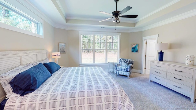 bedroom featuring ceiling fan, carpet floors, ornamental molding, and a tray ceiling