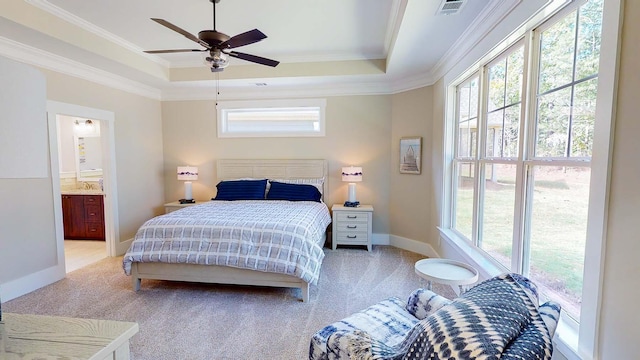 bedroom with carpet flooring, connected bathroom, ceiling fan, a raised ceiling, and ornamental molding