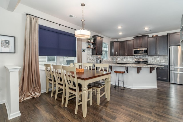 dining space featuring sink and dark wood-type flooring