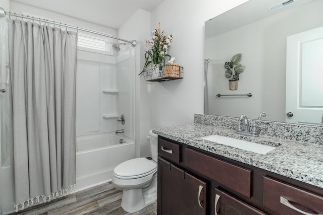 full bathroom featuring hardwood / wood-style flooring, vanity, shower / bath combo, and toilet