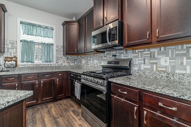 kitchen featuring tasteful backsplash, appliances with stainless steel finishes, dark hardwood / wood-style flooring, and light stone countertops