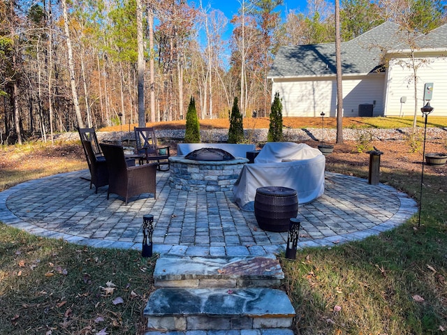 view of patio / terrace with a fire pit and cooling unit