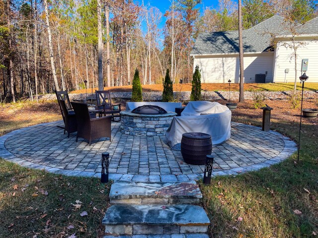 view of patio / terrace with a fire pit and cooling unit