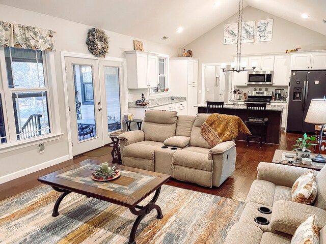 living room featuring high vaulted ceiling, french doors, sink, dark hardwood / wood-style floors, and a notable chandelier