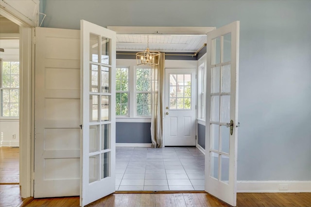 doorway featuring hardwood / wood-style floors, a notable chandelier, and french doors