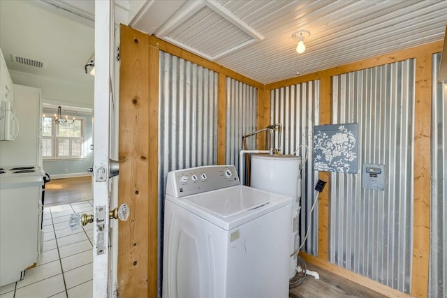 washroom featuring a chandelier, washer / dryer, water heater, and light tile patterned floors