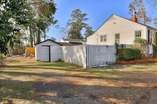 view of side of home with a yard and a storage unit