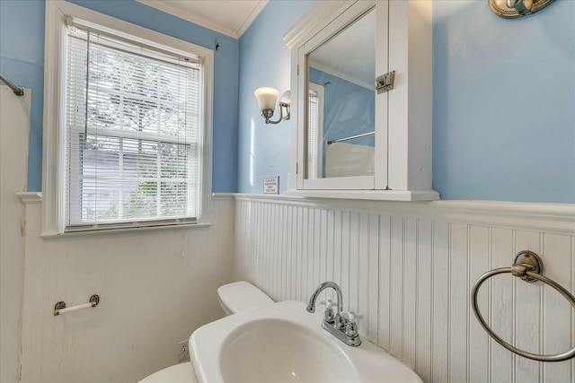 bathroom with crown molding, toilet, and sink