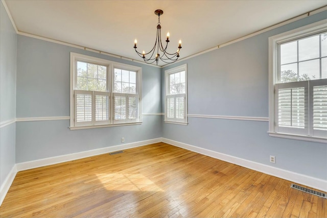 unfurnished room featuring a notable chandelier, crown molding, and hardwood / wood-style floors