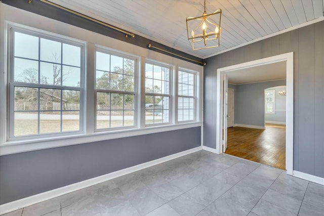 empty room featuring crown molding, plenty of natural light, a notable chandelier, and wood ceiling