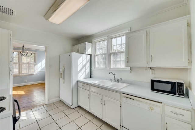 kitchen with white cabinetry, sink, white appliances, and light tile patterned floors