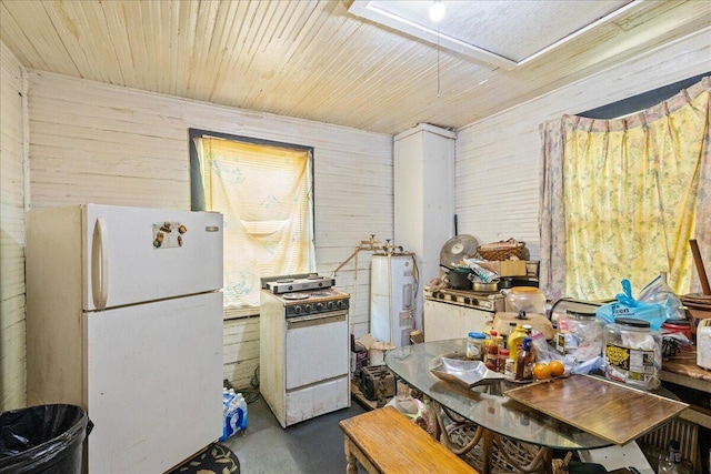 kitchen featuring white appliances, wooden walls, and concrete floors