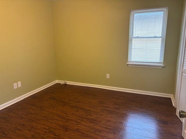 unfurnished room with dark wood-type flooring