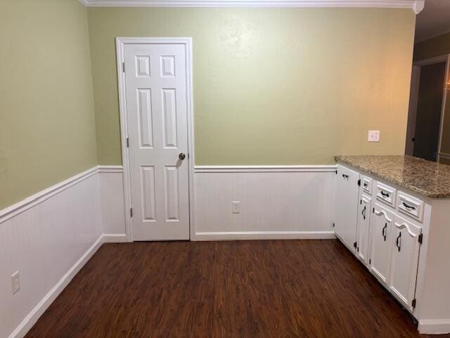 kitchen featuring crown molding, dark hardwood / wood-style flooring, light stone countertops, and white cabinets