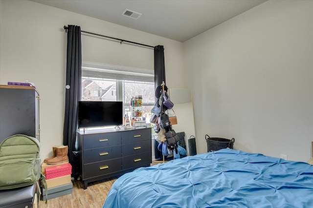 bedroom with light wood-type flooring and visible vents