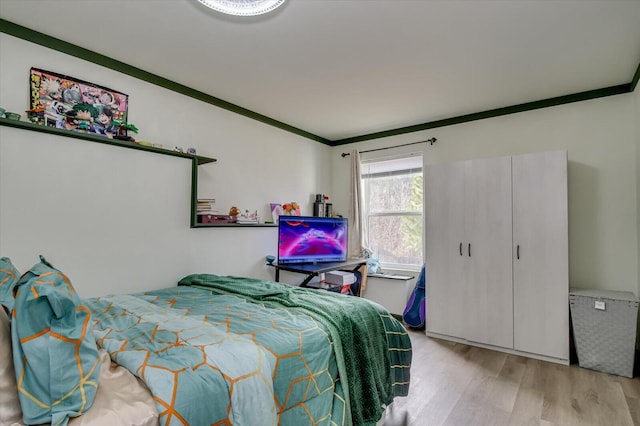 bedroom featuring ornamental molding and light wood-style floors