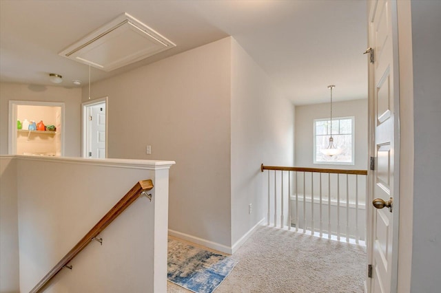 corridor with baseboards, carpet floors, an upstairs landing, and attic access