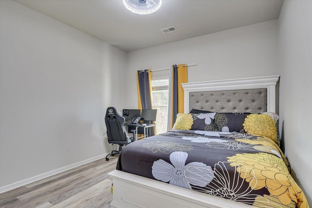 bedroom featuring light wood finished floors, baseboards, and visible vents