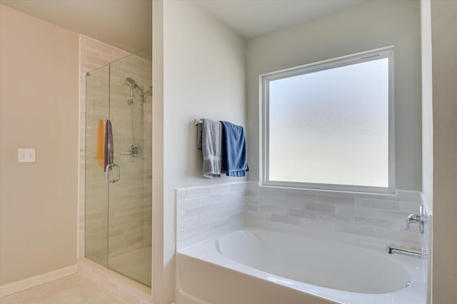 full bath with a stall shower, tile patterned flooring, baseboards, and a bath