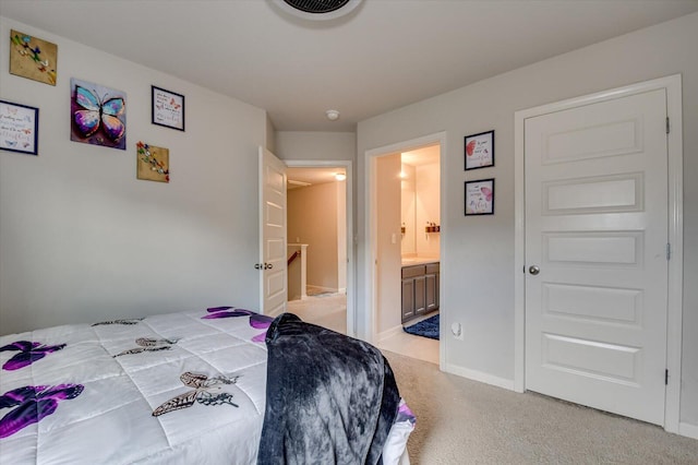 carpeted bedroom featuring baseboards and connected bathroom